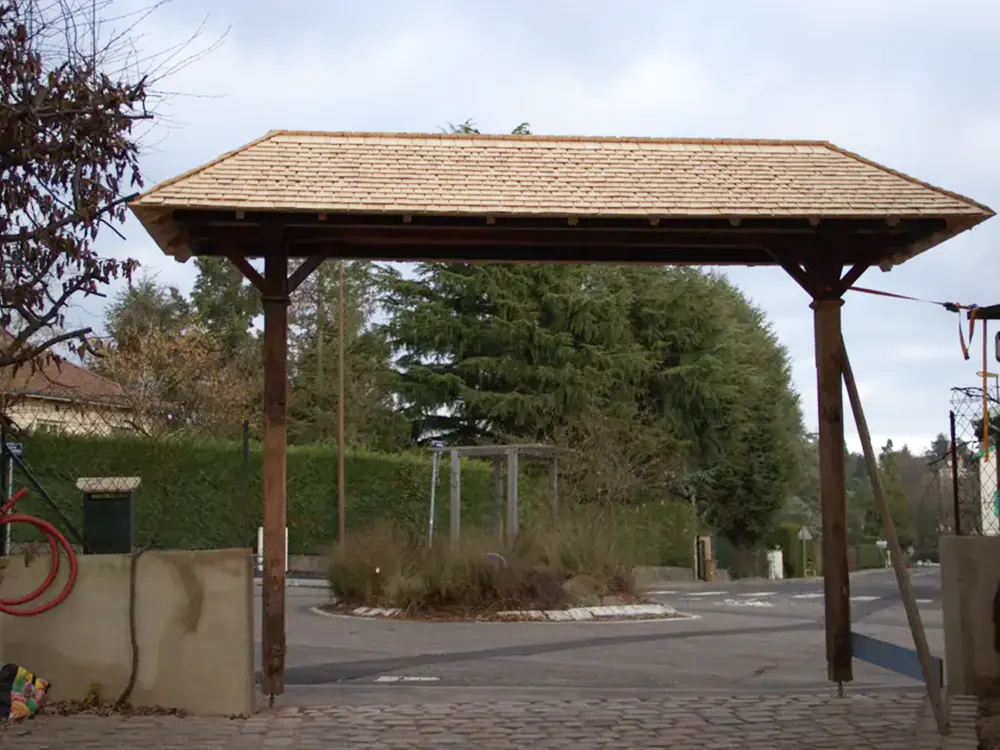 Auvent de portail restauré avec toiture en tavaillons de bois, vue d’ensemble