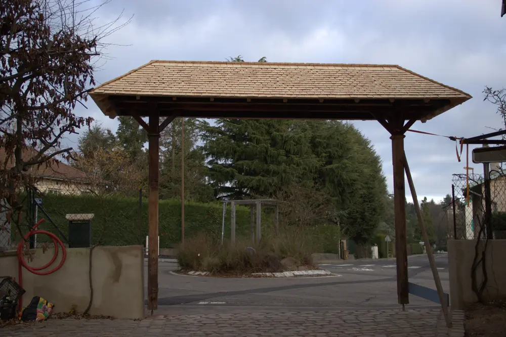 Finition de la couverture en tavaillons de bois d’un auvent de portail ancien