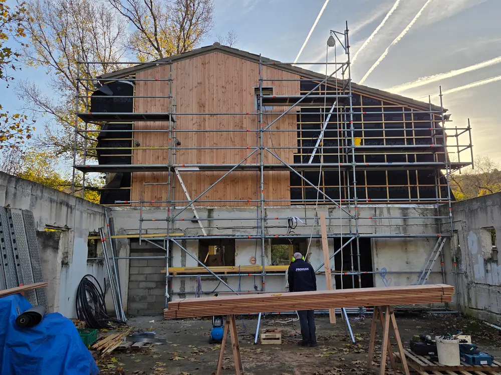Façade d’un bâtiment habillée de bardage bois après travaux d’ITE